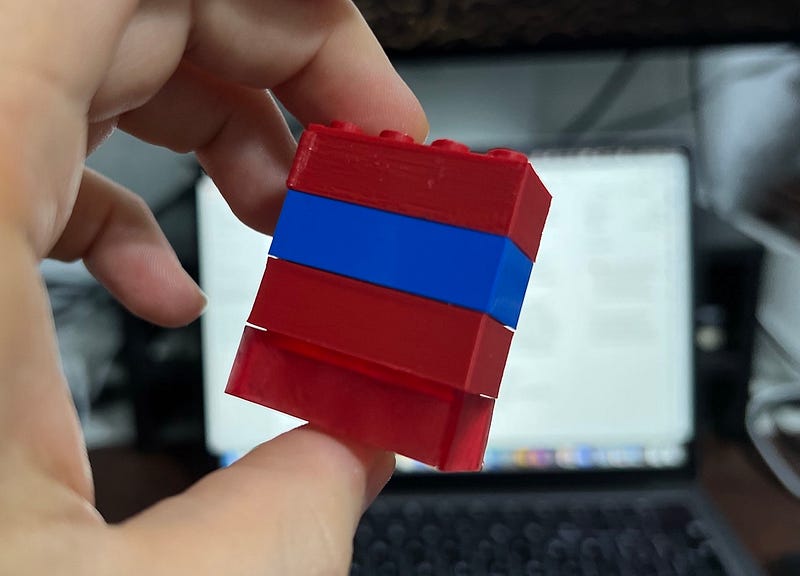 Stacked printed bricks alongside a genuine LEGO brick.